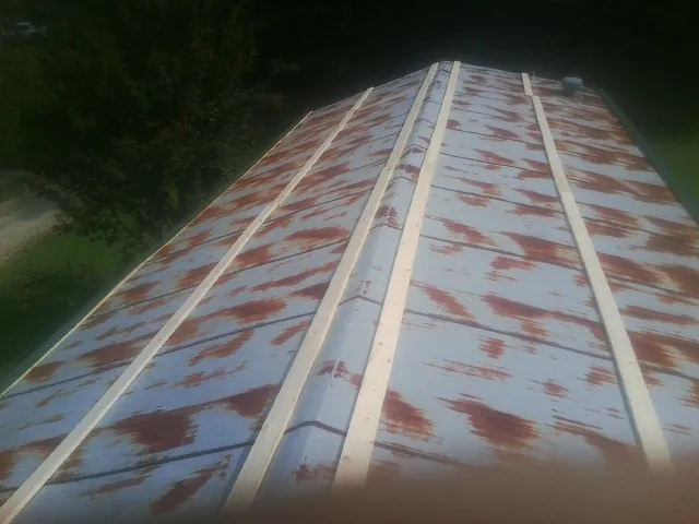 Rusted metal roof panels with new wood purlins before replacement — Storm Damage Roof Repair in Boylston by Roofing Brothers