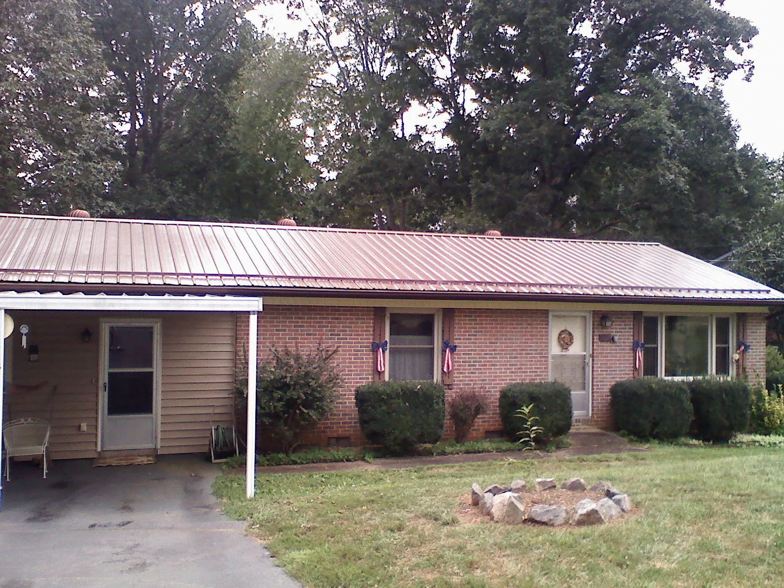 Bronze metal roof and carport on a brick ranch home — Roof Repair work by our crew in Boylston
